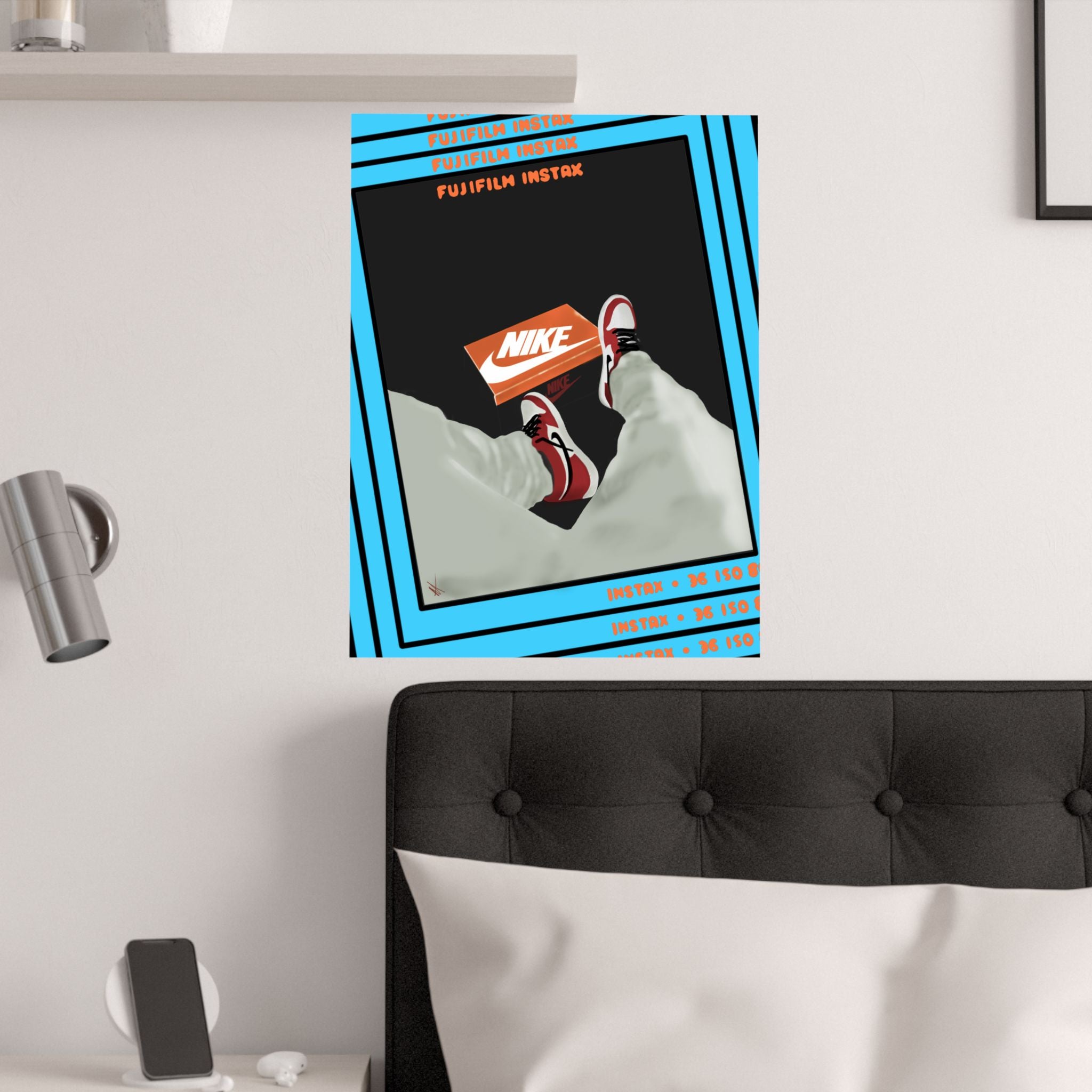 Poster of a Nike shoe box with a Fujifilm Instax camera on a wall above a bed.